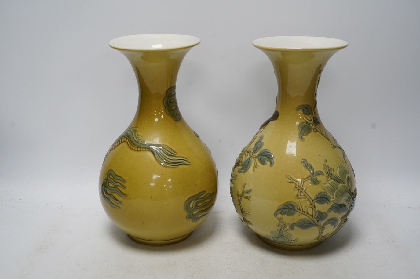 Two Lladro vases decorated in relief with dragons and birds, 26cm high. Condition - good